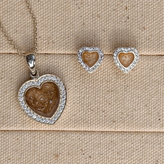 A heart necklace and earring set with cubic zirconia stones and a champagne centre with visible ash.