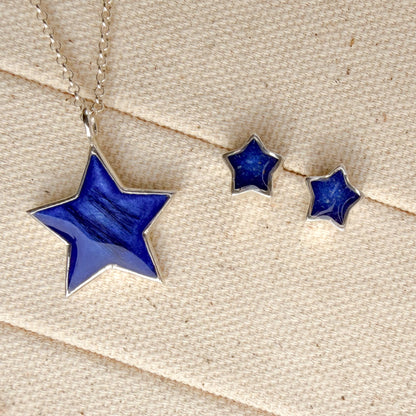 A Star sterling silver necklace and matching stud earrings set, featuring deep blue inlay with visible hair inclusion the the pendant and visible ash in the earrings. 