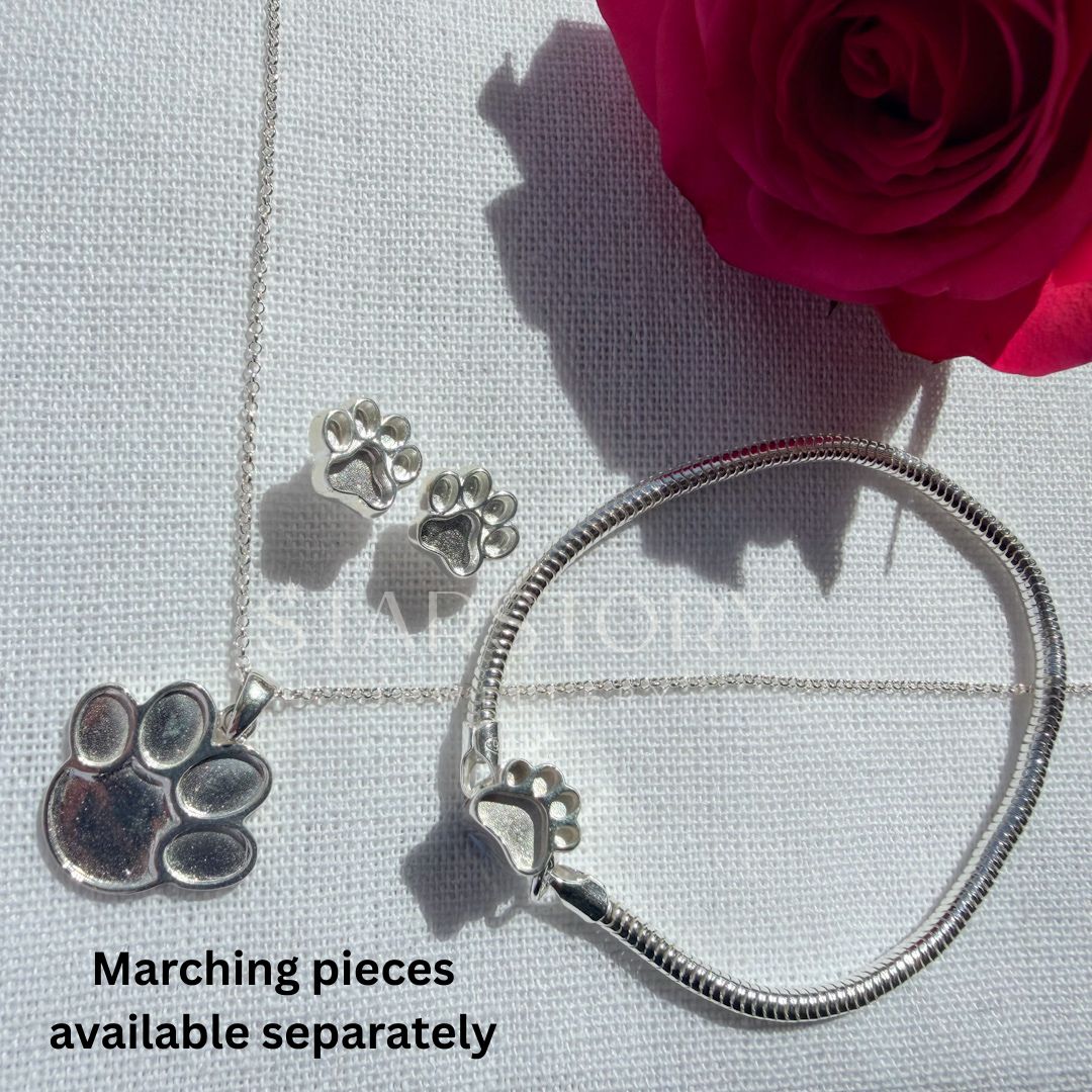 Pawprint Memorial necklace, stud earrings and charm bracelet set in sterling silver for ash, hair or fur. 