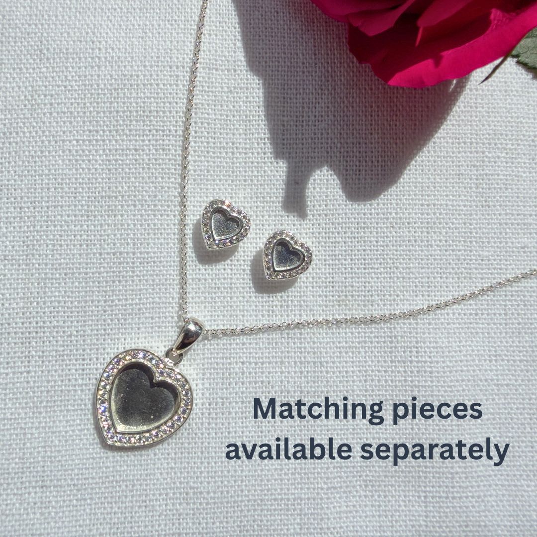 Silver heart-shaped necklace and earrings on a light gray background with text 'Matching pieces available separately'.